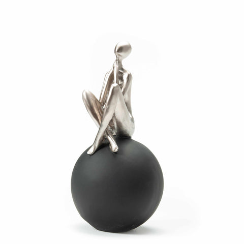 Figure Sitting on Black Ball