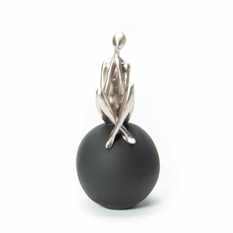 Figure Sitting on Black Ball