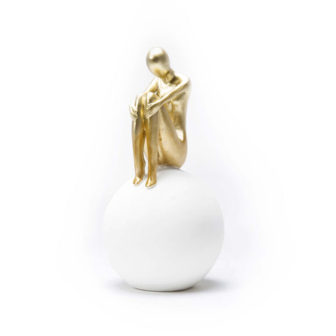 Figure Sitting on White Ball